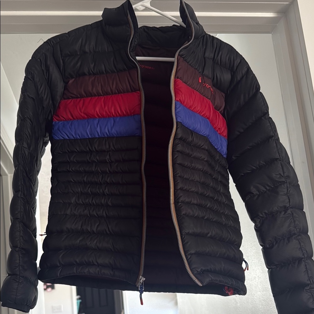 Cotopaxi Black Puffer Jacket with Red and Blue Accents